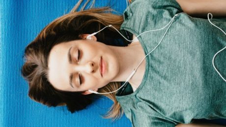 woman laying down with headphones in